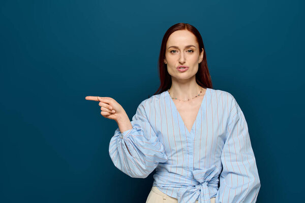 A passionate language instructor with red hair teaches sign language against a blue backdrop.