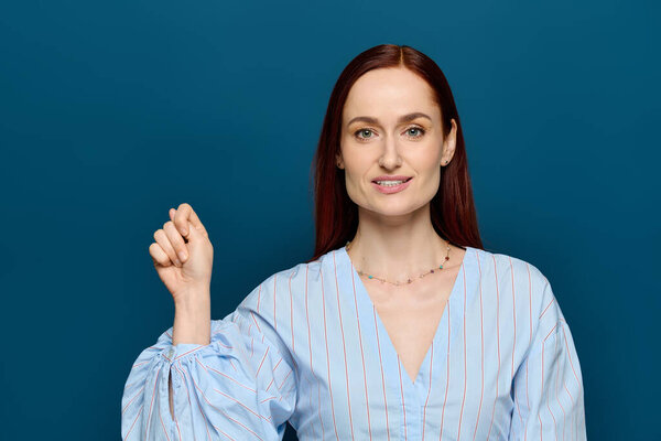 A language teacher with red hair demonstrates sign language to her students in a calm setting.