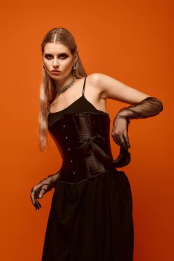 Göz kamaştırıcı genç bir kadın çarpıcı bir Cadılar Bayramı kostümü giyer..