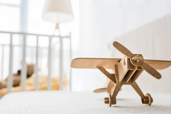 Avión de juguete de madera retro en el sofá en la habitación del vivero — Stock Photo