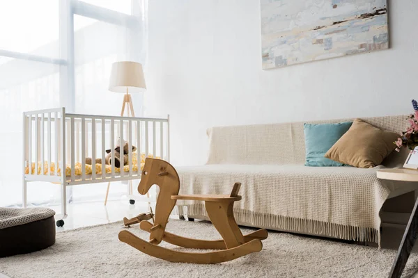 Modern interior design of nursery room with crib and rocking horse chair — Stock Photo