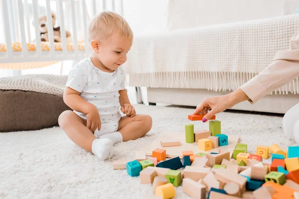 Adorable toddler playing with colorful cubes in nursery room — Stock Photo