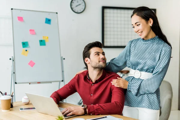 Multiethnische Kollegen, die an Projekten arbeiten und Laptop im Büro nutzen — Stockfoto