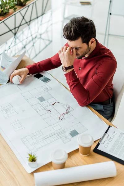 Stressato architetto di sesso maschile con mal di testa mentre si lavora sul progetto in ufficio — Foto stock