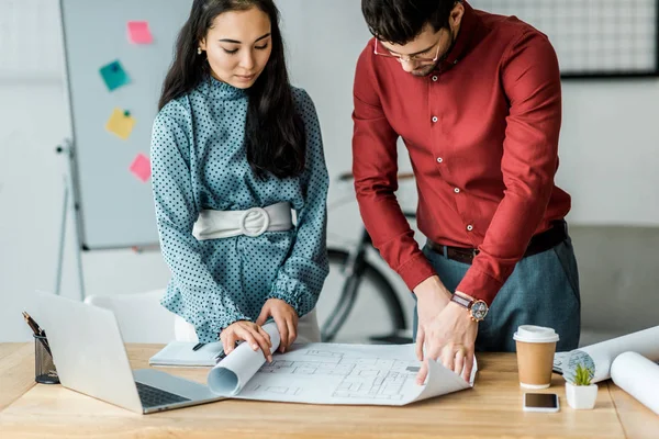 Couple d'architectes travaillant sur les plans au bureau — Photo de stock