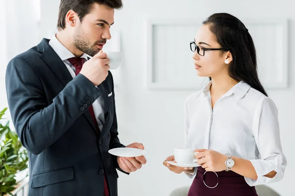 Multiethnic colleagues having coffee break on office — Stock Photo