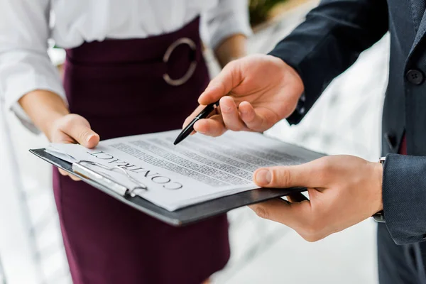 Vista recortada de los empresarios que firman contrato en el cargo - foto de stock