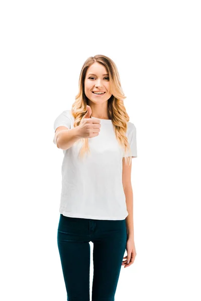 Attractive blonde girl showing thumb up and smiling at camera isolated on white — Stock Photo