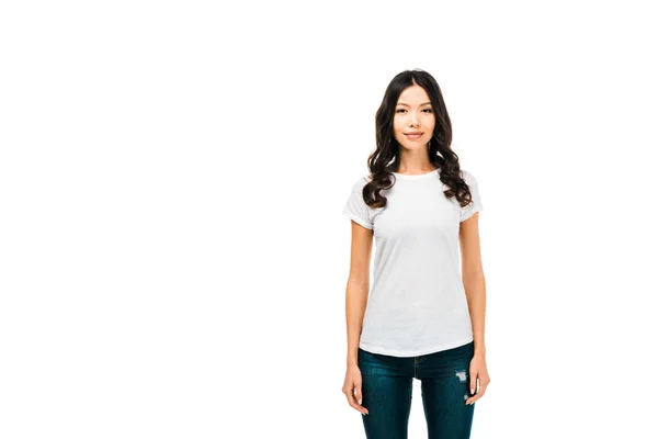 Attractive young woman in white t-shirt standing and smiling at camera isolated on white — Stock Photo