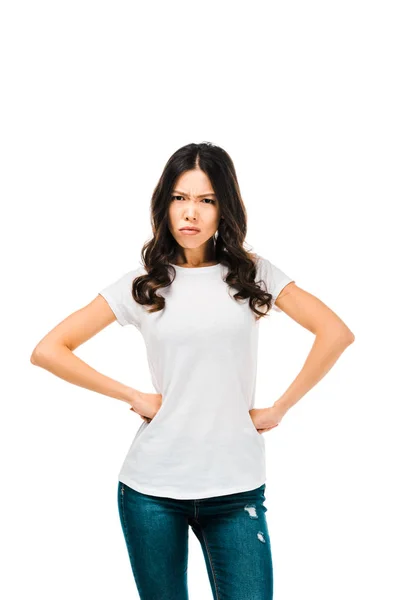 Angry young woman standing with hands on waist and looking at camera isolated on white — Stock Photo