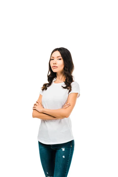 Confident young woman standing with crossed arms and looking at camera isolated on white — Stock Photo