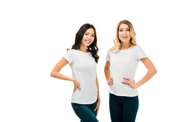 Красиві щасливі дівчата в білих футболках, що стоять разом і посміхаються на камеру ізольовані на білому — стокове фото