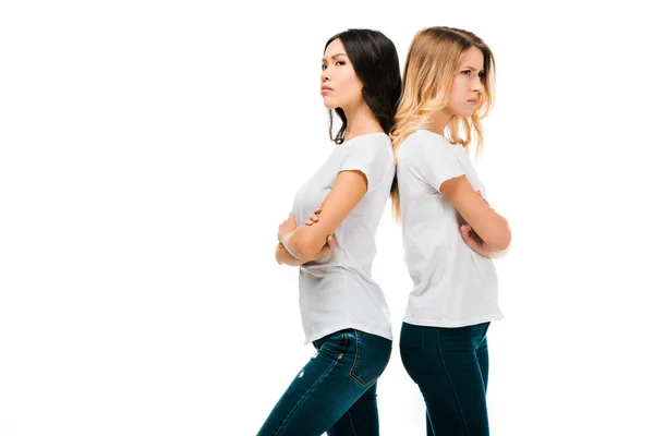 Side view of upset girls standing back to back with crossed arms isolated on white — Stock Photo