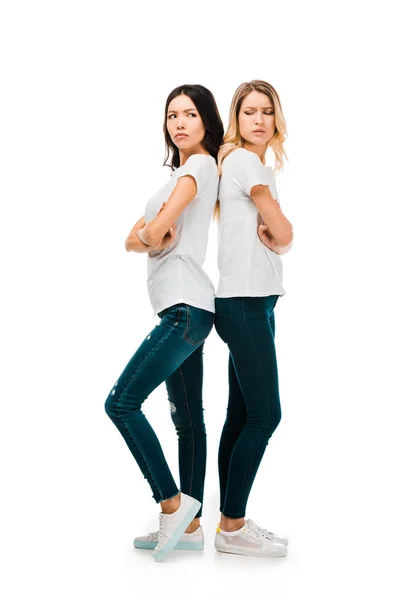 Full length view of upset young women standing back to back with crossed arms isolated on white — Stock Photo