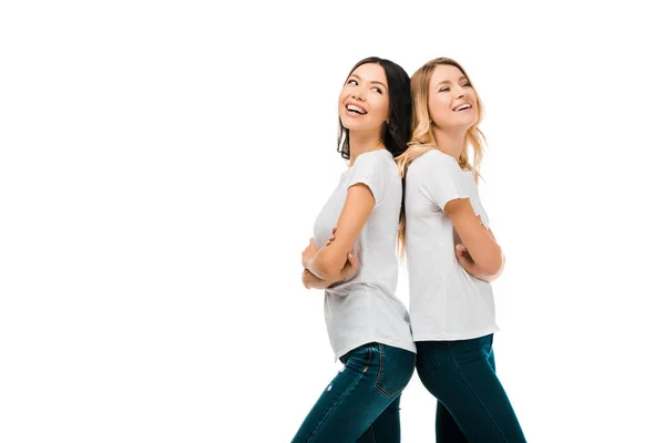 Vue latérale de belles jeunes femmes heureuses debout dos à dos et riant isolé sur blanc — Photo de stock