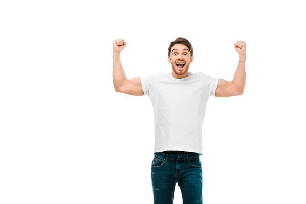 Joven emocionado mostrando los músculos y sonriendo a la cámara aislado en blanco - foto de stock