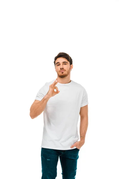 Confident young man showing ok sign and looking at camera isolated on white — Stock Photo