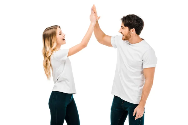 Feliz jovem casal dando alta cinco e sorrindo uns aos outros isolado no branco — Fotografia de Stock