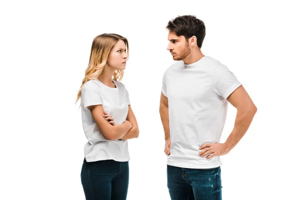 Joven pareja molesta mirándose el uno al otro aislar en blanco - foto de stock