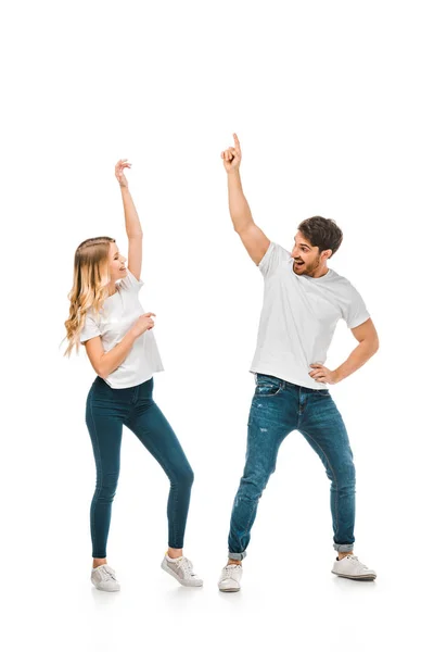 Feliz joven pareja bailando y sonriendo unos a otros aislados en blanco - foto de stock