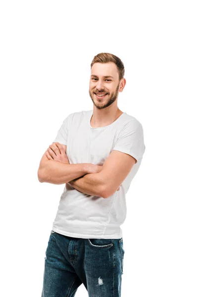 Guapo joven feliz de pie con los brazos cruzados y sonriendo a la cámara aislado en blanco - foto de stock