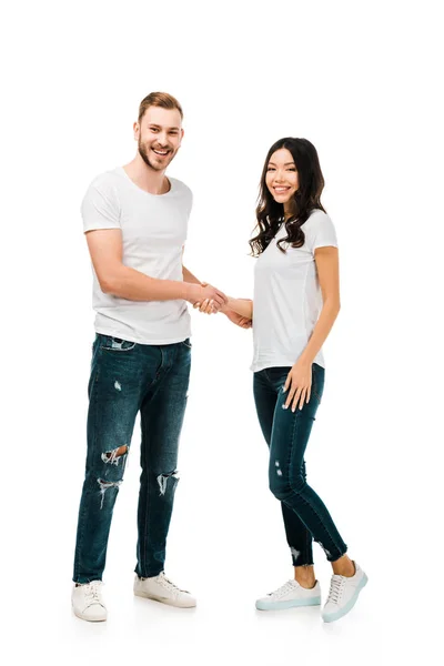 Happy young couple shaking hands and smiling at camera isolated on white — Stock Photo