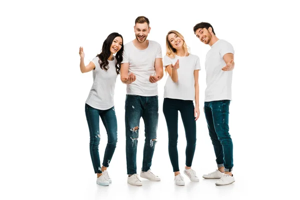 Happy young men and women in white t-shirts gesturing with hands and smiling at camera isolated on white — Stock Photo