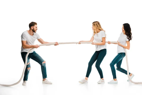 Emocional joven hombre y mujeres tirando de la cuerda aislado en blanco - foto de stock