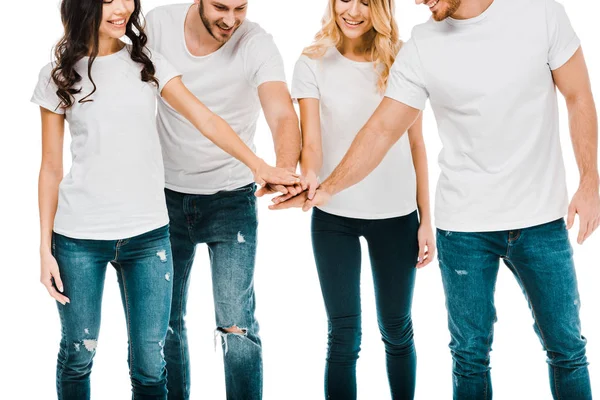 Cropped shot of smiling young men and women stacking hands isolated on white — Stock Photo