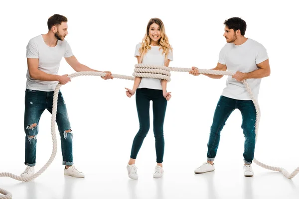 Jeunes hommes tenant la corde enroulée autour souriant jeune femme montrant pouces vers le haut et regardant la caméra isolée sur blanc — Photo de stock