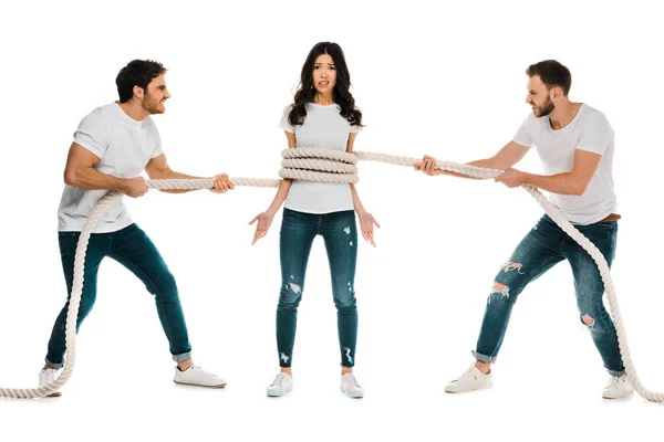 Разъяренные мужчины тянут веревку вокруг напуганной молодой женщины, изолированной на белом — стоковое фото