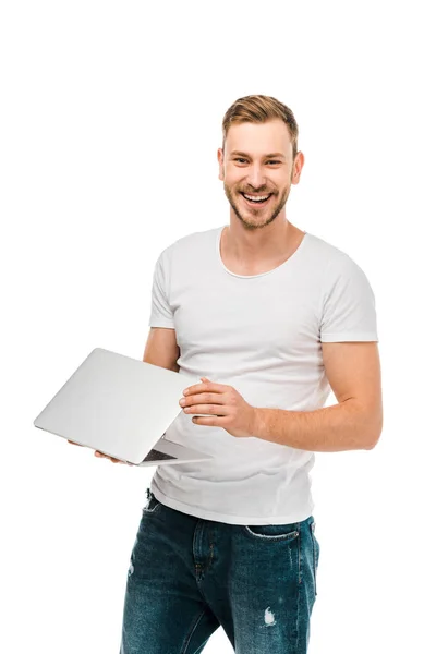 Schöner junger Mann hält Laptop in der Hand und lächelt in die Kamera isoliert auf weiß — Stockfoto
