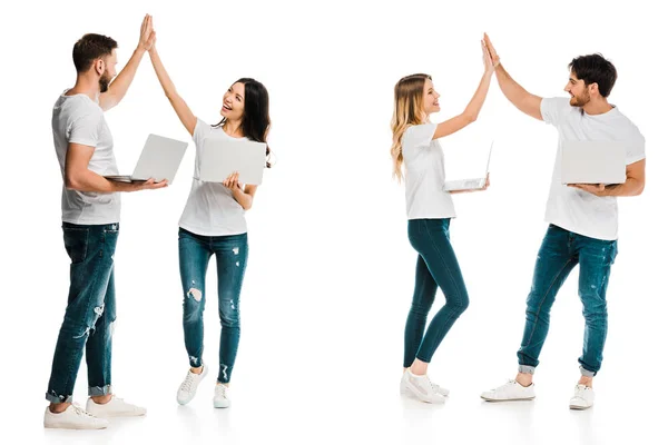 Happy young couples holding laptops and giving high five isolated on white — Stock Photo