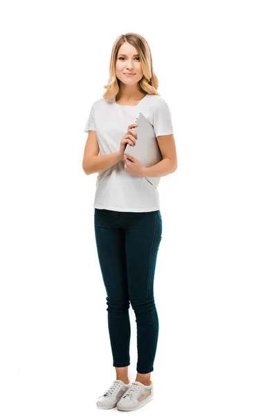 Attractive blonde girl holding laptop and smiling at camera isolated on white — Stock Photo