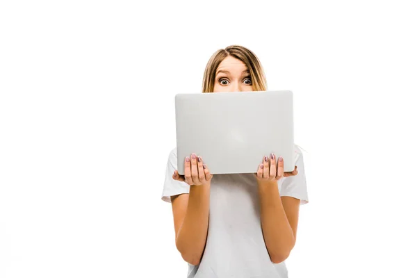 Schockierte junge Frau hält Laptop in der Hand und blickt isoliert auf weiße Kamera — Stockfoto