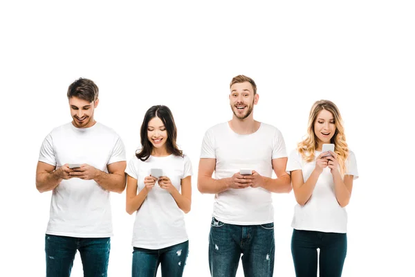 Happy young men and women in white t-shirts using smartphones isolated on white — Stock Photo