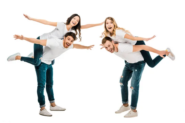 Heureux les jeunes couples piggybackking et sourire à la caméra isolé sur blanc — Photo de stock