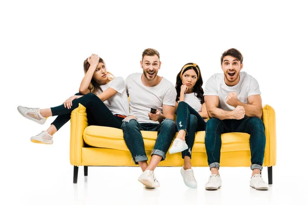 Hombres excitados y chicas aburridas sentadas en el sofá y viendo la televisión aislada en blanco - foto de stock