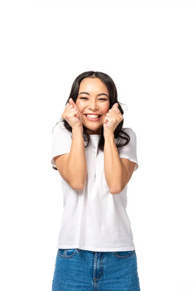 Lächelnd asiatische junge Frau hält Hand Fäuste in der Nähe Gesicht isoliert auf weiß — Stockfoto