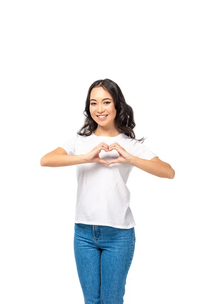 Улыбающаяся азиатка показывает знак сердца с руками, изолированными на белом — стоковое фото