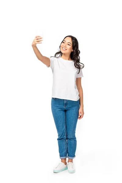 Sorrindo asiático menina no branco t-shirt e azul jeans tomando selfie isolado no branco — Fotografia de Stock