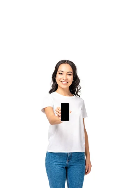 Hermosa chica asiática joven mostrando teléfono inteligente con pantalla en blanco aislado en blanco - foto de stock