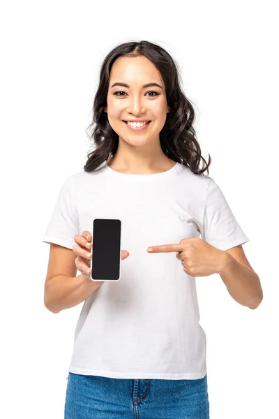 Молода азіатська дівчина вказує на смартфон з порожнім екраном ізольовано на білому — стокове фото