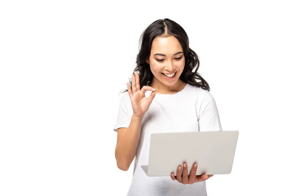 Jovem asiático mulher usando laptop e mostrando ok gesto isolado no branco — Fotografia de Stock