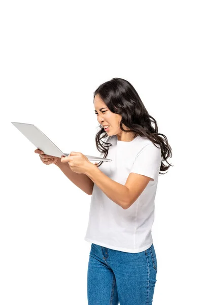 Mujer asiática joven estresada en camiseta blanca y pantalones vaqueros azules usando portátil aislado en blanco - foto de stock