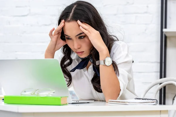 Freelancer serio mirando la pantalla del ordenador portátil y tomándose de la mano en la cabeza — Stock Photo