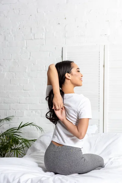 Asian woman in white t-shirt and grey leggings doing exercise with stretching arms — Stock Photo