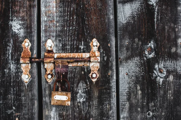 Vecchio serratura arrugginita intemperie su porta di legno gelido — Foto stock