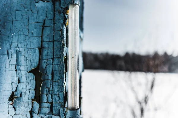 Foco seletivo do termômetro na placa azul velha intemperizada no inverno — Fotografia de Stock