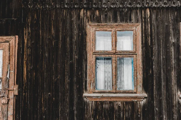 Envejecido envejecido casa de madera marrón con ventana - foto de stock